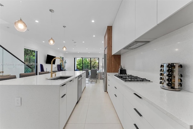 kitchen with sink, hanging light fixtures, a wealth of natural light, stainless steel appliances, and a large island