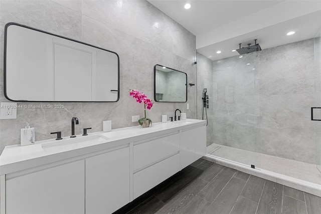 bathroom featuring vanity, tile walls, and a tile shower