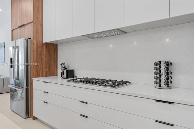 kitchen featuring white cabinetry, backsplash, light tile patterned floors, and stainless steel appliances