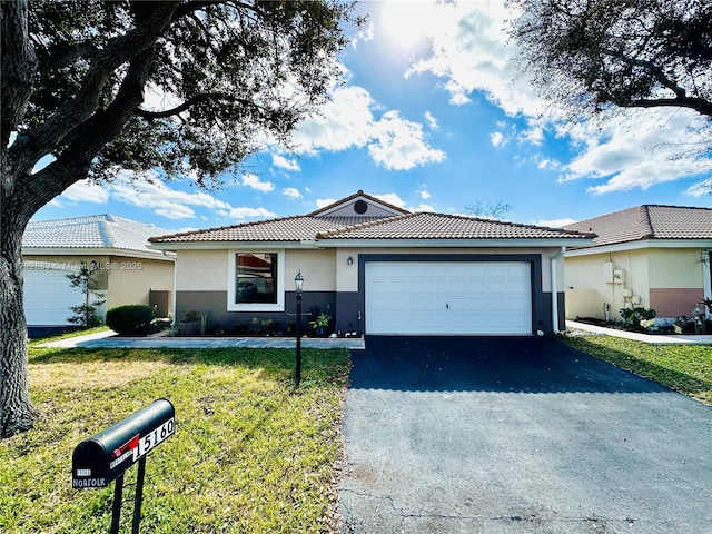 ranch-style house with a garage and a front lawn