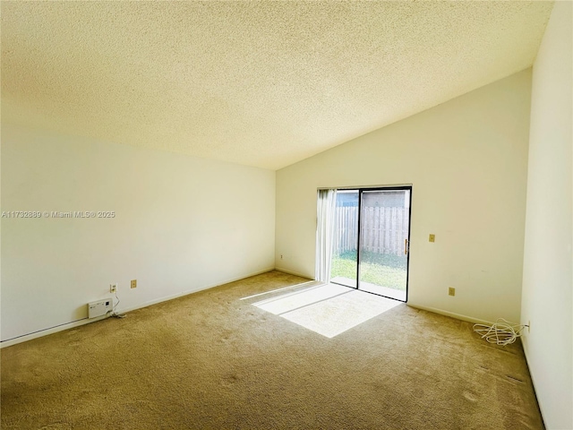 carpeted empty room featuring vaulted ceiling and a textured ceiling