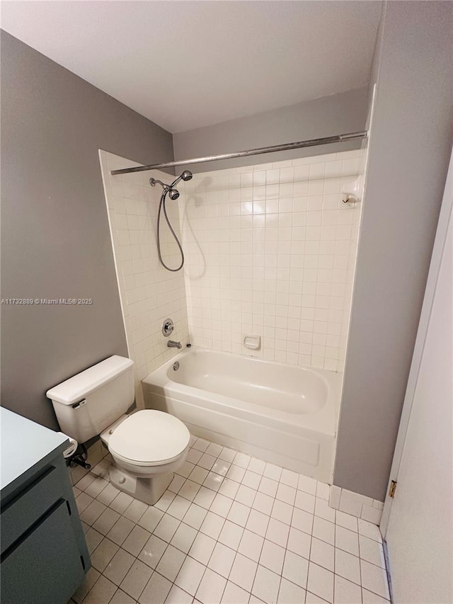 full bathroom featuring vanity, tiled shower / bath, tile patterned floors, and toilet