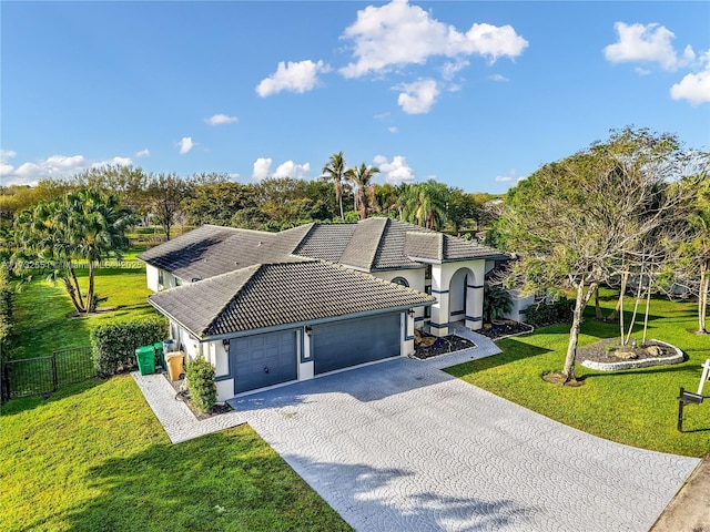 view of front of house featuring an attached garage, a front yard, fence, driveway, and a tiled roof