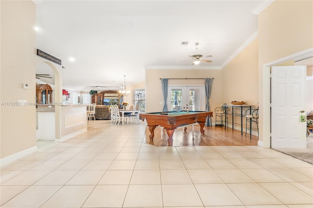 recreation room featuring ornamental molding, arched walkways, french doors, and light tile patterned flooring