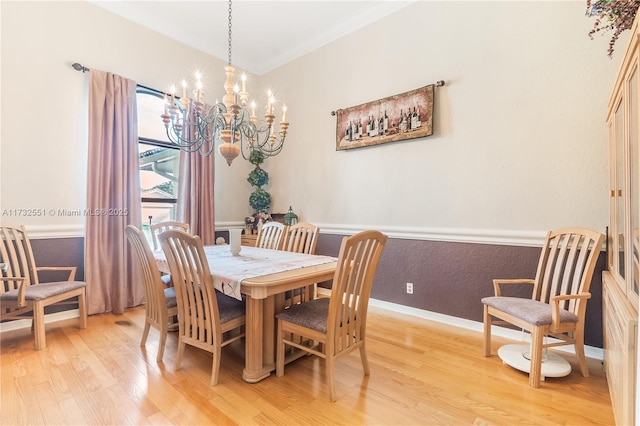 dining space with an inviting chandelier, light wood-style flooring, baseboards, and crown molding