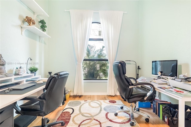 office space featuring light wood-type flooring and baseboards