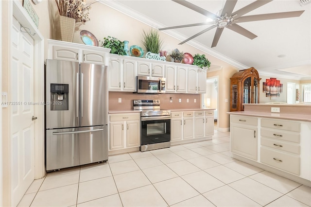 kitchen featuring light tile patterned floors, light countertops, backsplash, appliances with stainless steel finishes, and ornamental molding