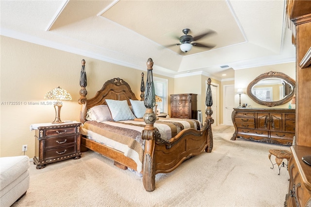 bedroom featuring ornamental molding, ceiling fan, a tray ceiling, and carpet