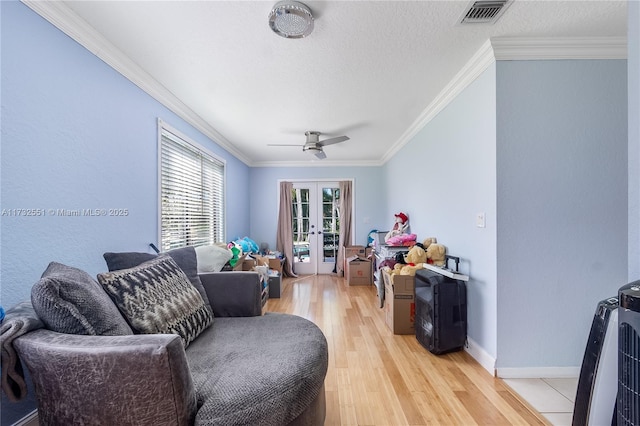 living area with ornamental molding, french doors, light wood finished floors, and visible vents