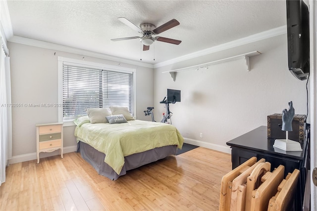 bedroom with a textured ceiling, ornamental molding, baseboards, and light wood-style floors