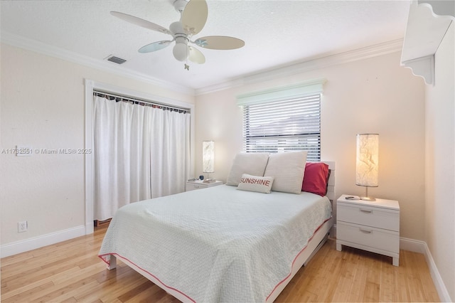 bedroom with baseboards, visible vents, ceiling fan, ornamental molding, and light wood-type flooring