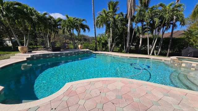 view of pool with a patio area and a pool with connected hot tub