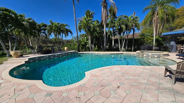 view of pool with a pool with connected hot tub and a patio