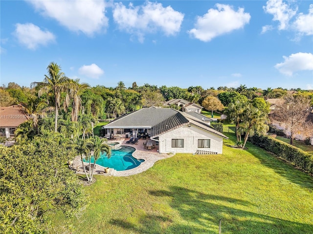 rear view of house featuring an outdoor pool, a lawn, and a patio