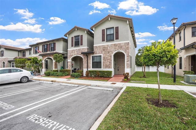 view of front property featuring central AC and a front yard