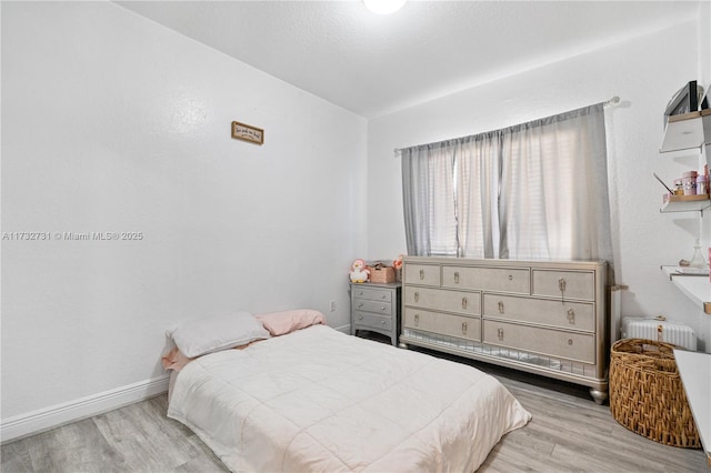 bedroom featuring lofted ceiling and light wood-type flooring