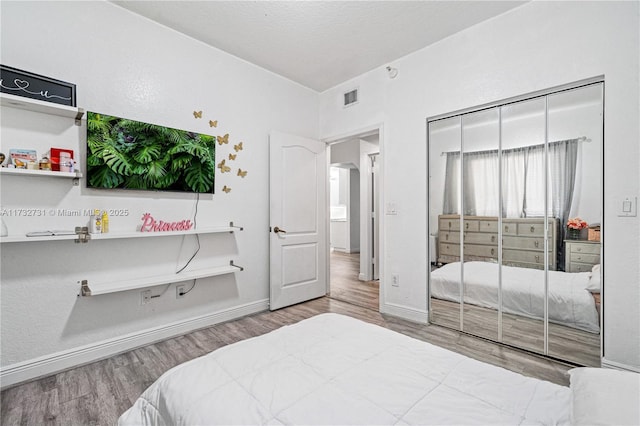 bedroom featuring wood-type flooring and a closet