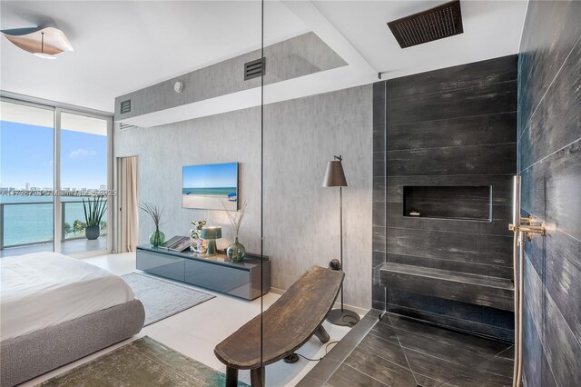 living room with a wealth of natural light, expansive windows, and a water view