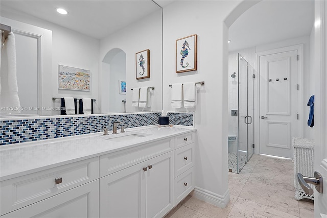 bathroom with tasteful backsplash, vanity, and walk in shower