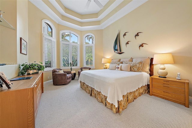 carpeted bedroom featuring ceiling fan, ornamental molding, and a raised ceiling