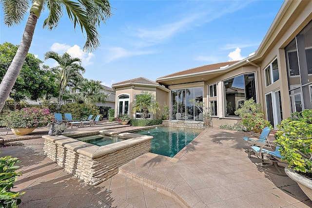 view of pool with a patio area and an in ground hot tub