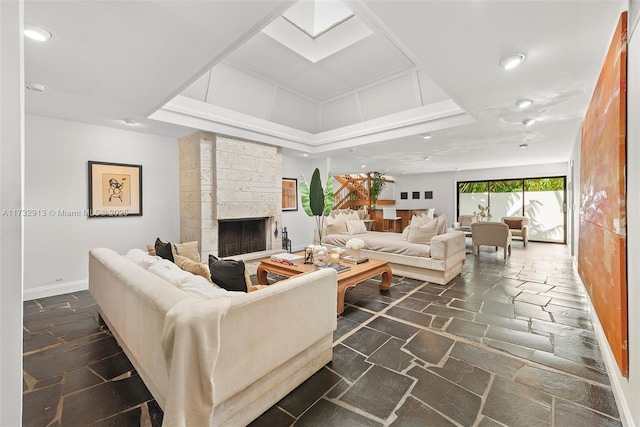 living area with baseboards, a fireplace, stone tile flooring, and recessed lighting