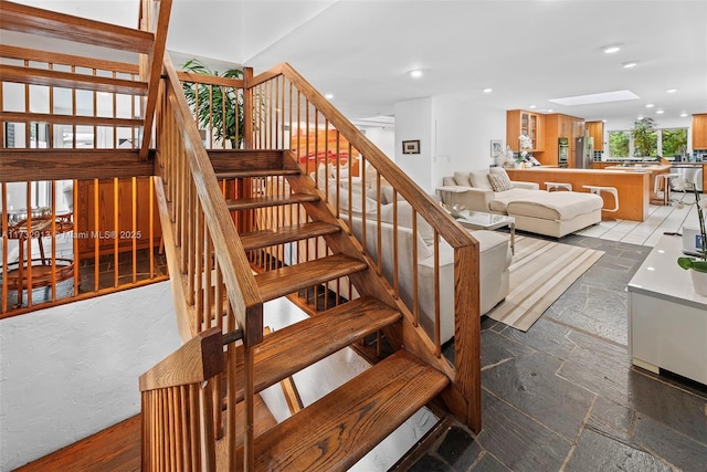stairway featuring recessed lighting and stone tile flooring
