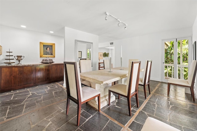 dining area featuring recessed lighting, rail lighting, and stone tile floors