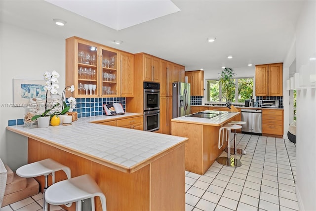 kitchen with light tile patterned floors, tasteful backsplash, a breakfast bar area, and stainless steel appliances