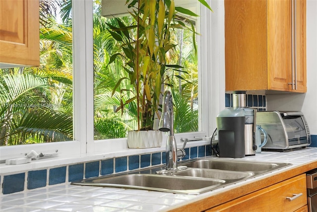kitchen with tile counters and brown cabinets