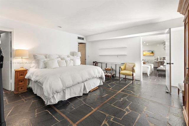 bedroom with stone tile flooring and visible vents