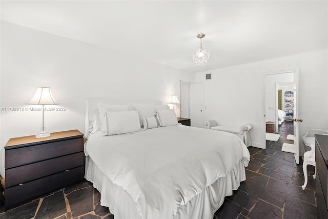 bedroom featuring stone finish floor, visible vents, and baseboards