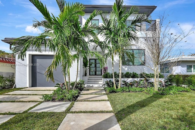 view of front of property featuring a garage and a front lawn