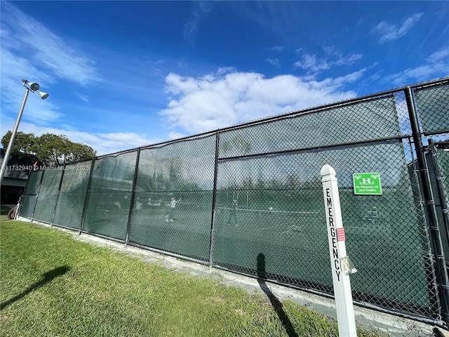 view of sport court with a yard