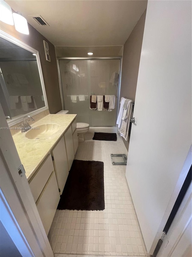 bathroom with an enclosed shower, vanity, and toilet