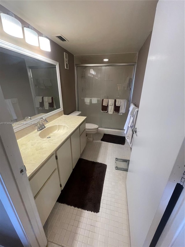 bathroom with vanity, a shower with shower door, and toilet