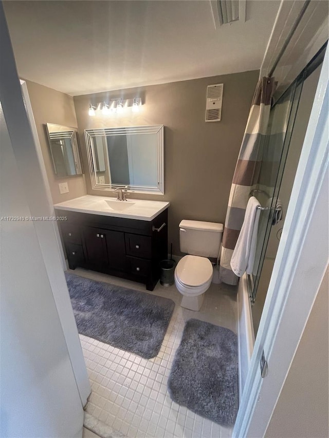 bathroom with vanity, toilet, and walk in shower