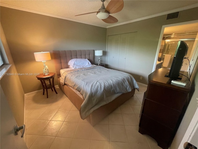 bedroom with light tile patterned floors, crown molding, ceiling fan, a textured ceiling, and a closet