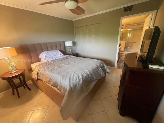 tiled bedroom with ornamental molding, a closet, ceiling fan, and ensuite bathroom