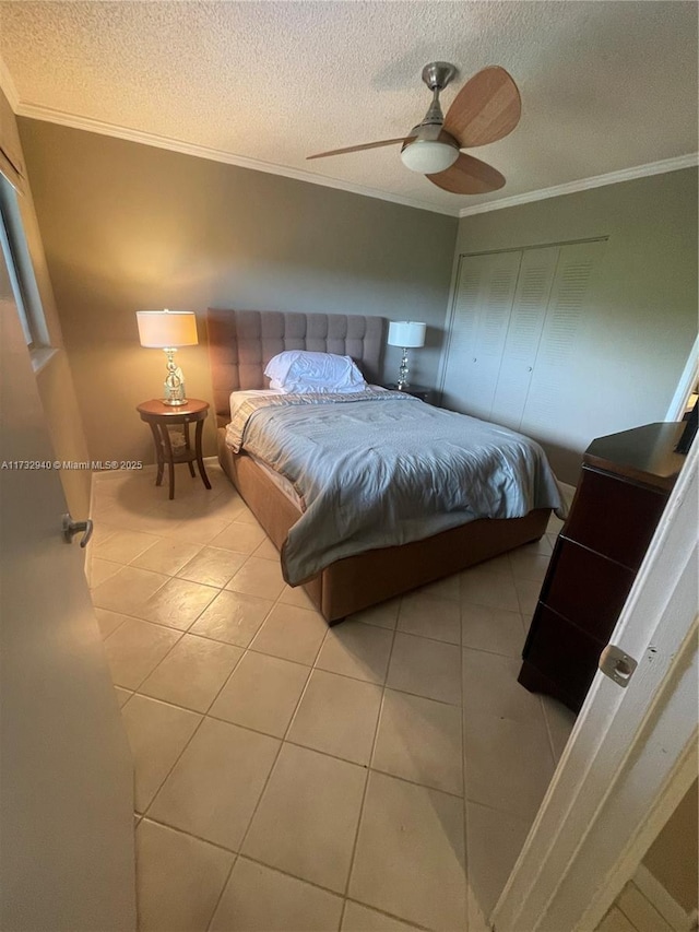 tiled bedroom with crown molding, ceiling fan, and a textured ceiling