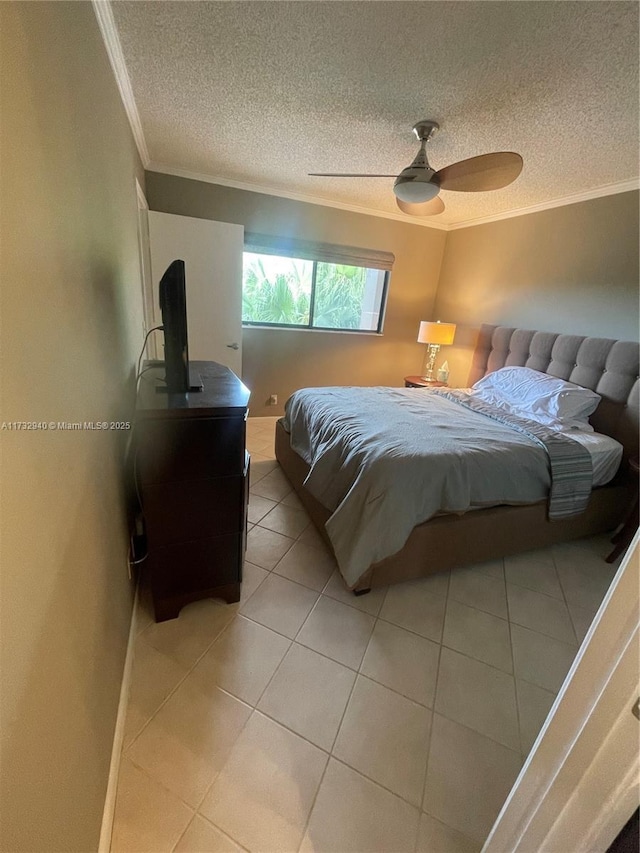 tiled bedroom featuring ornamental molding, a textured ceiling, and ceiling fan