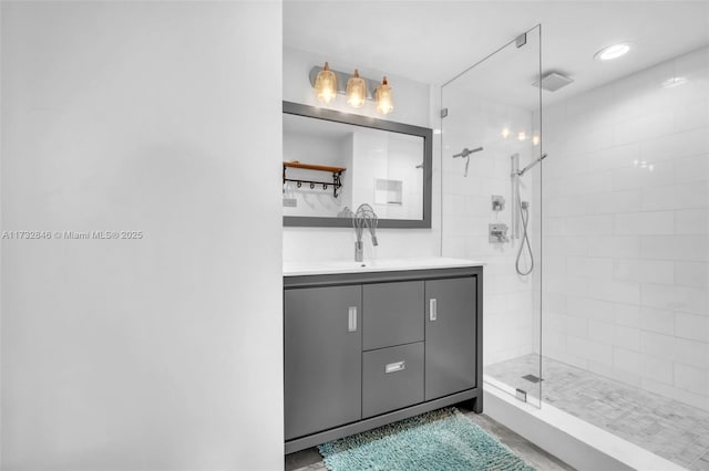 bathroom with vanity and a tile shower