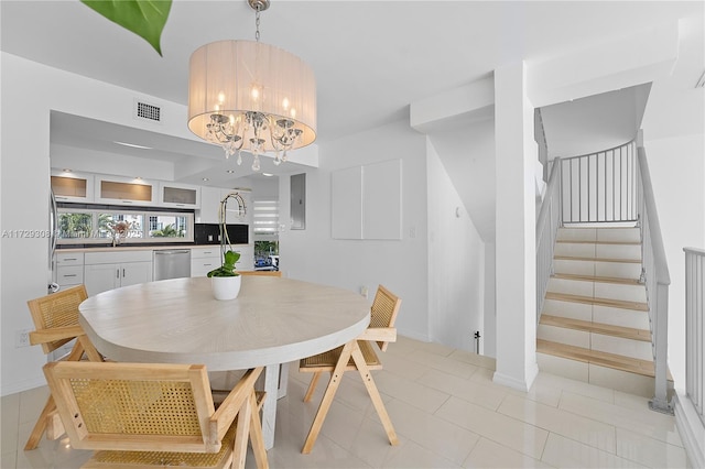 dining area featuring sink and an inviting chandelier