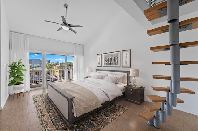 bedroom with light wood-type flooring, ceiling fan, high vaulted ceiling, and access to outside