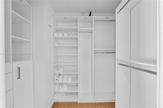 spacious closet featuring light hardwood / wood-style floors