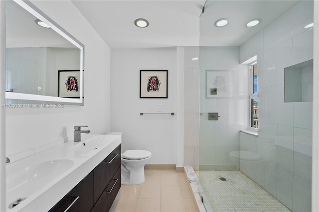 bathroom with tiled shower, tile patterned floors, toilet, and vanity