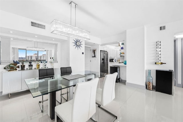 dining room featuring light tile patterned flooring and a chandelier