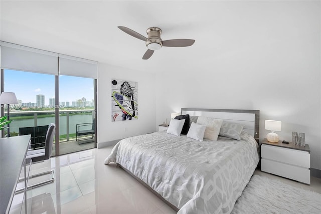 bedroom featuring light tile patterned floors, access to outside, ceiling fan, and a water view