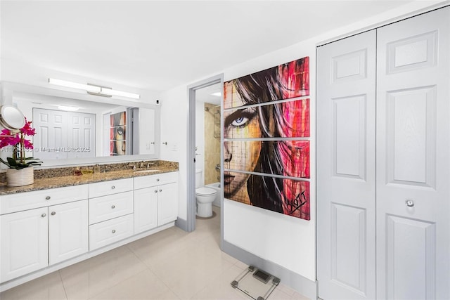 bathroom featuring vanity, tile patterned floors, and toilet