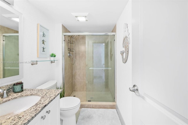 bathroom featuring vanity, toilet, and a shower with door